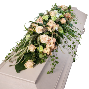 Kista dekorerad med en blomstergirlang av ljusa rosor, orkidéer och gröna blad.