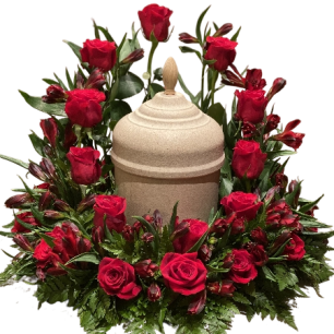 En urna omgiven av en krans av röda rosor och gröna blad.